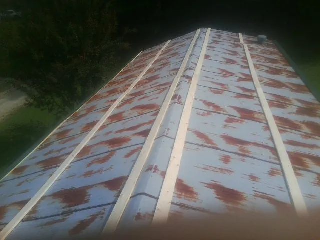 Rusted metal roof panels with new wood purlins before replacement — Storm Damage Roof Repair in Bronson by Roofing Brothers
